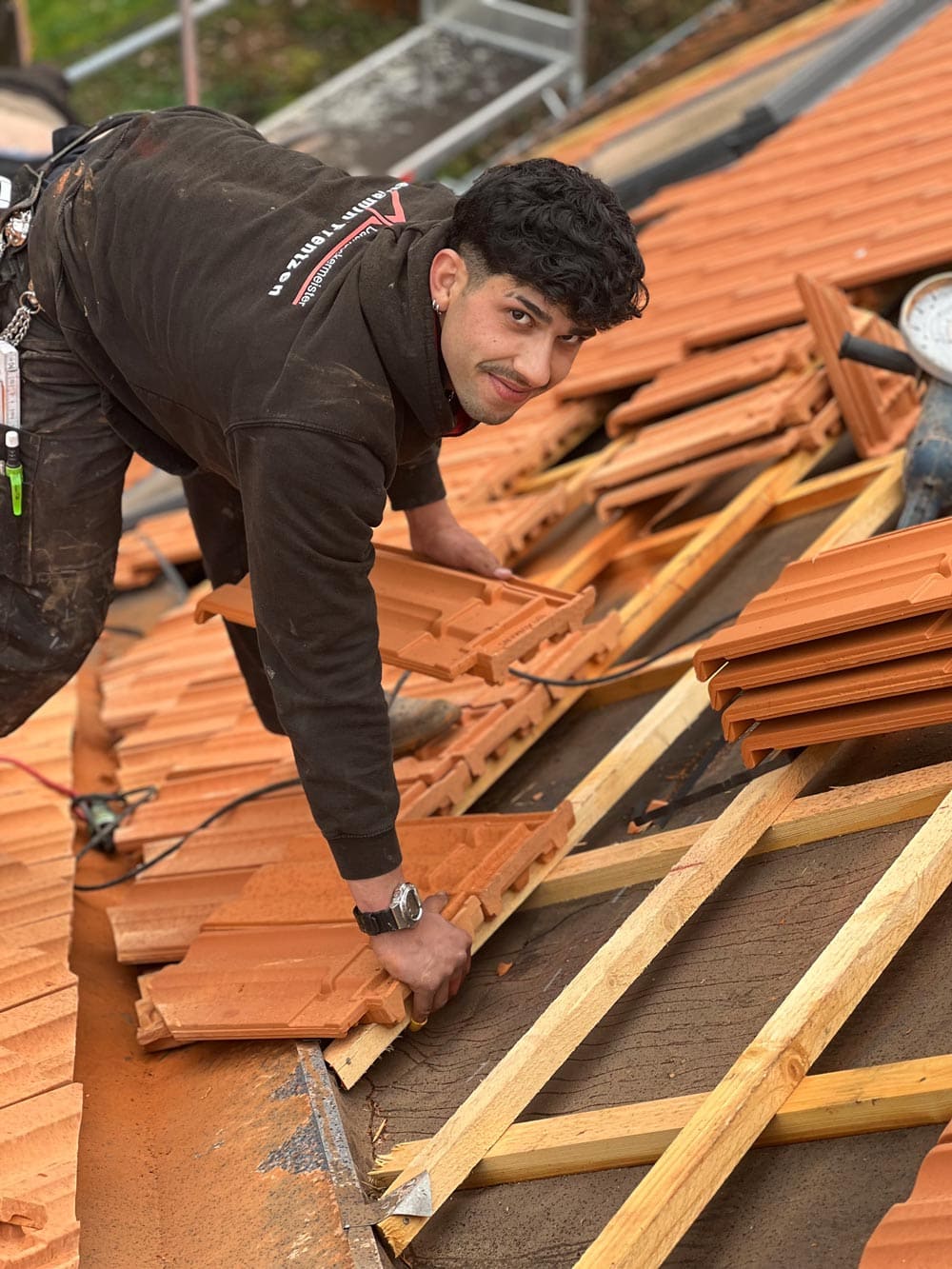 Dachdecker beim Anbringen von Keramik Dachziegel in Mönchengladbach 
