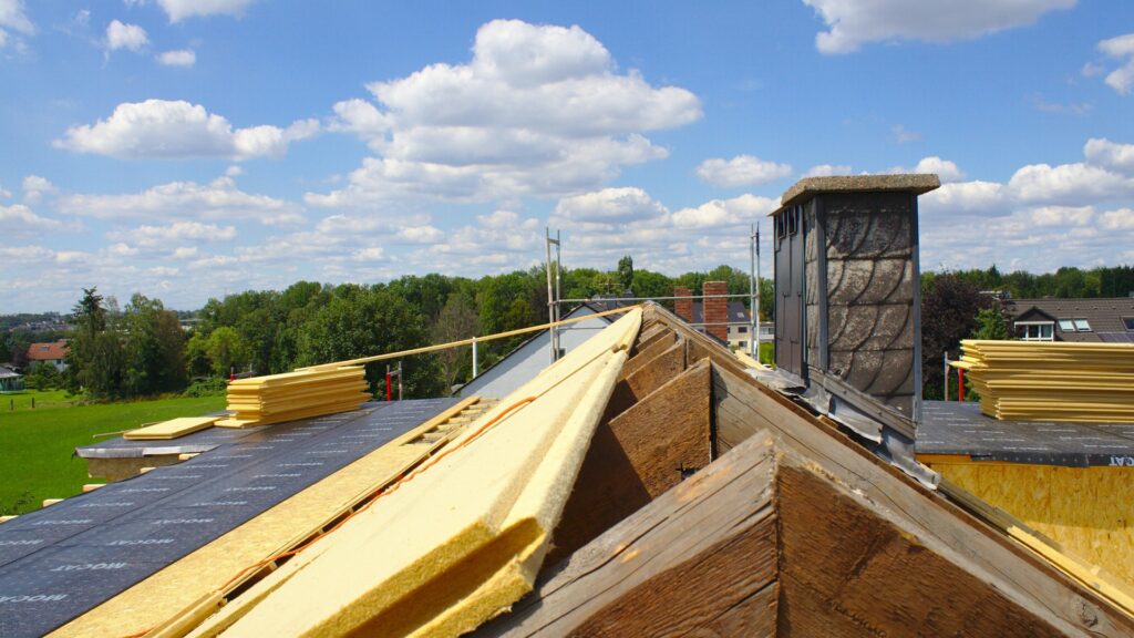 Dachsanierung mit Wärmedämmung auf einer Baustelle bei sonnigem Wetter